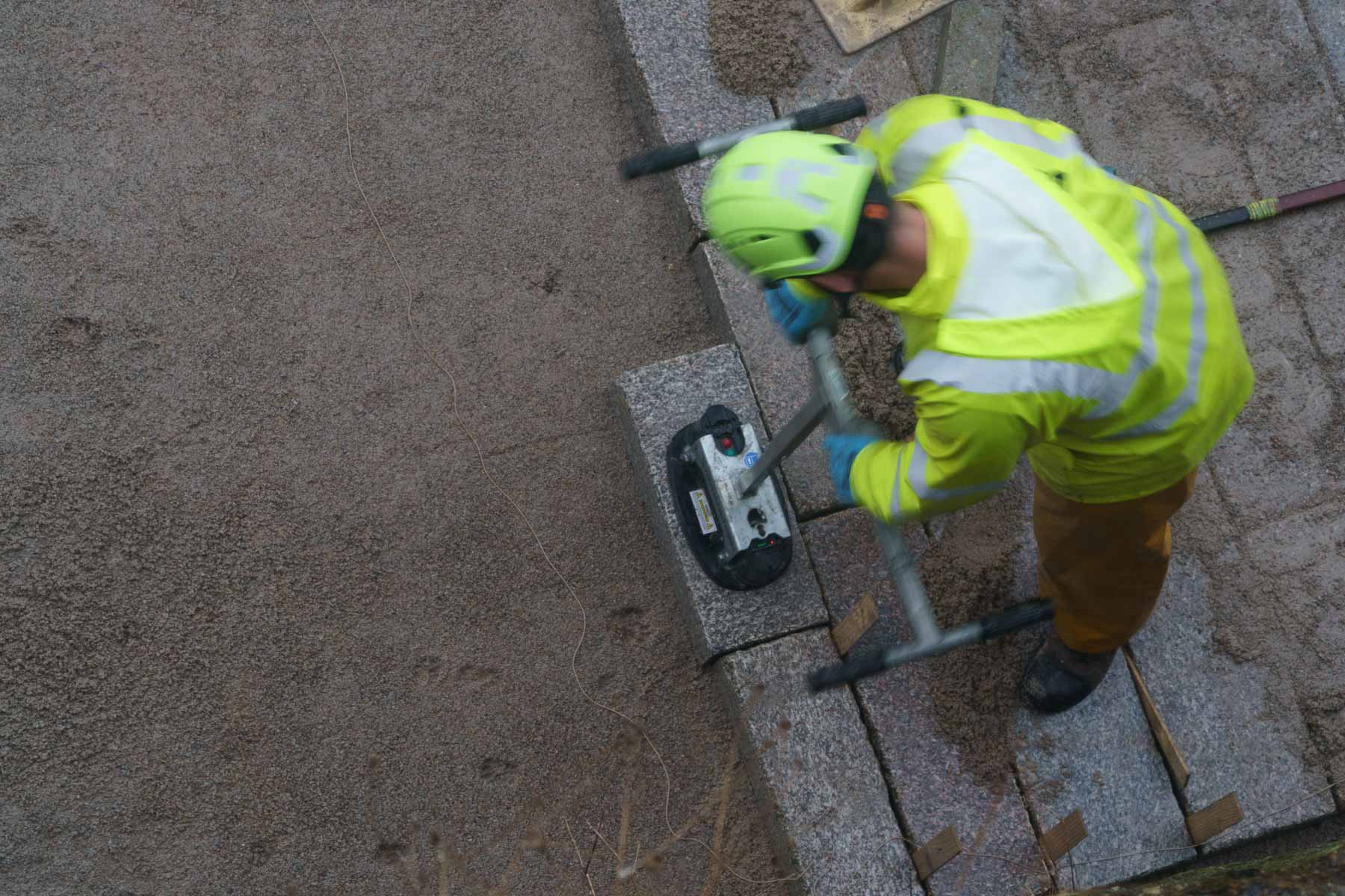 Suction is used to lift a stone sett for positioning